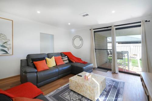 a living room with a couch and a table at Urban Virgo Escape in Caversham
