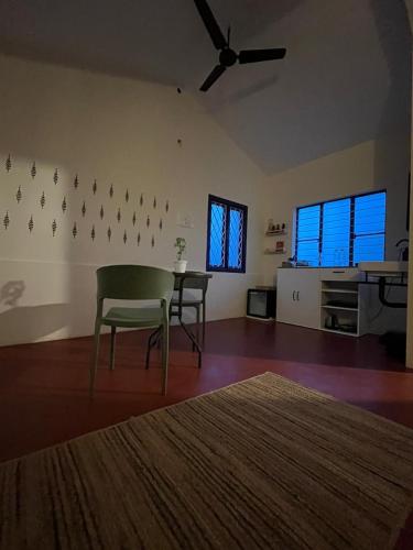 a living room with a table and chairs and a ceiling fan at MyYearlyStay in Udupi - Colonial in Udupi