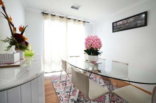 a dining room with a glass table and chairs at Urban Virgo Escape in Caversham