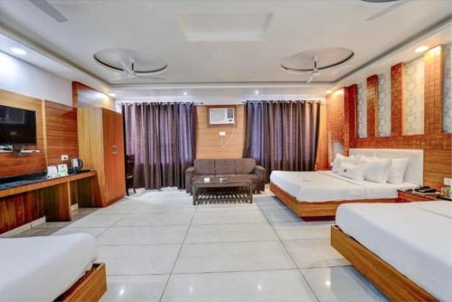 a hotel room with two beds and a couch at Pushap villa katra in Katra