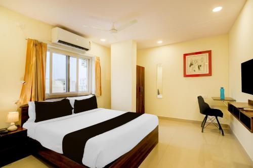 a bedroom with a bed and a desk and a television at Super Townhouse De Alphabet Hotel - Gandimaissamma in Hyderabad