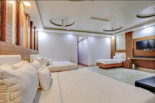 a bedroom with two beds and a flat screen tv at Pushap villa katra in Katra