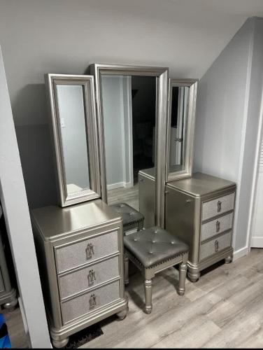 a room with two dressers and a chair and mirrors at Beach Apt In Woodmontmilford in Milford