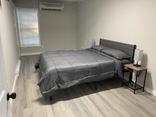 a bedroom with a bed and a table with a lamp at Private Apt In Southfordsouthbury in Southbury