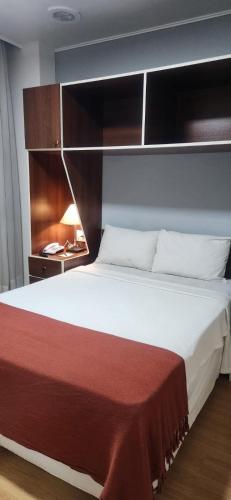 a bedroom with a large bed with a red blanket at City Hotel- Mercado Publico, Prefeitura Municipal in Porto Alegre