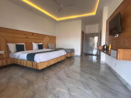 a bedroom with a large bed and a flat screen tv at The Edge Retreat A Premium Property in Mussoorie