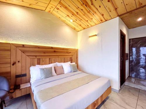a bedroom with a large white bed with a wooden ceiling at The Edge Retreat A Premium Property in Mussoorie