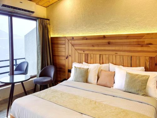 a bedroom with a bed and a table and a window at The Edge Retreat A Premium Property in Mussoorie