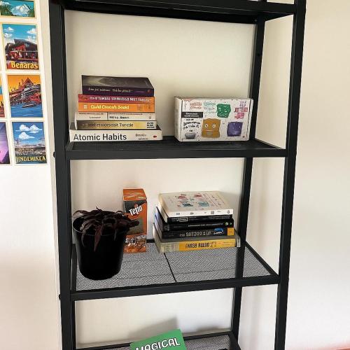 a book shelf with books and other items on it at MyYearlyStay in Udupi - Colonial in Udupi