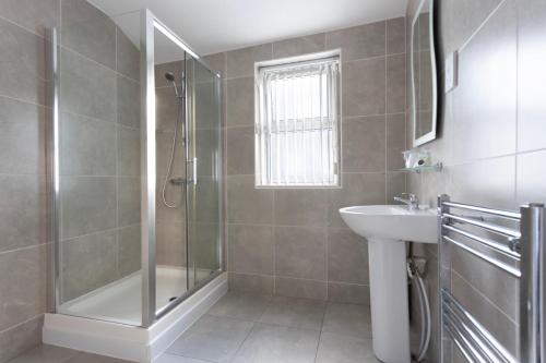 a bathroom with a shower and a sink at Orrell Park Hotel in Liverpool
