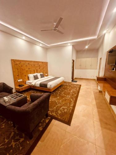 a bedroom with a bed and a living room with a couch at The Edge Retreat A Premium Property in Mussoorie