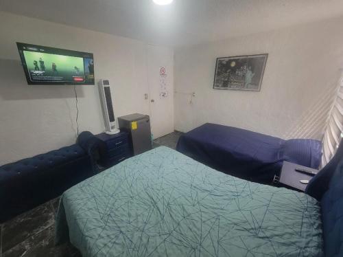 a bedroom with two beds and a flat screen tv at Aguilas House 2 Alojamiento entero 3 habitaciones in Guadalajara