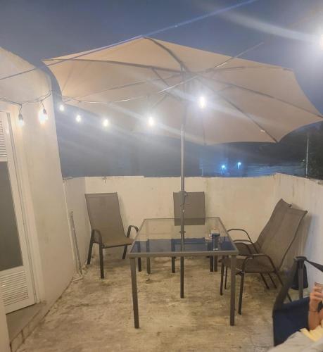 a table and chairs under a white umbrella at Aguilas House 2 Alojamiento entero 3 habitaciones in Guadalajara