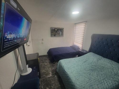 a bedroom with a bed and a flat screen tv at Aguilas House 2 Alojamiento entero 3 habitaciones in Guadalajara