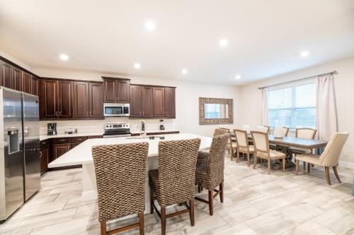 a large kitchen with a table and chairs at Chic Home With Private Pool, Game Room And Waterpark & Resort Access Near Disney At Encore Resorts Reunion - 320Au in Kissimmee