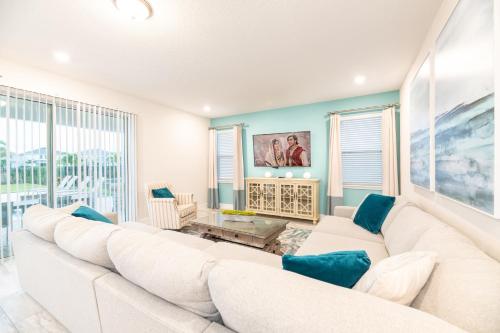 a white living room with a large white couch at Chic Home With Private Pool, Game Room And Waterpark & Resort Access Near Disney At Encore Resorts Reunion - 320Au in Kissimmee