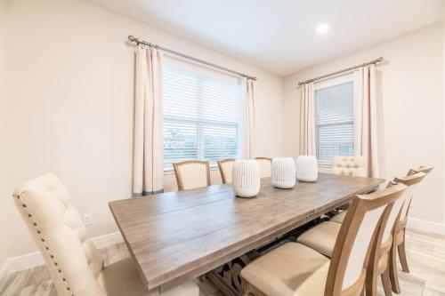 a dining room with a wooden table and chairs at Chic Home With Private Pool, Game Room And Waterpark & Resort Access Near Disney At Encore Resorts Reunion - 320Au in Kissimmee