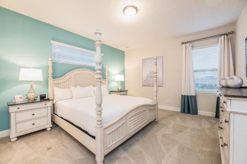 a bedroom with a white bed and blue walls at Chic Home With Private Pool, Game Room And Waterpark & Resort Access Near Disney At Encore Resorts Reunion - 320Au in Kissimmee