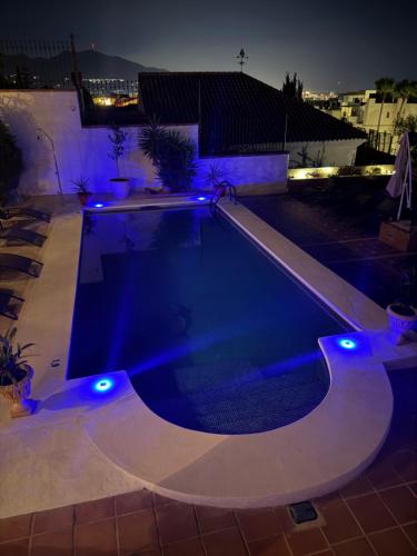a swimming pool lit up at night with blue lights at Amaca in Mijas Costa