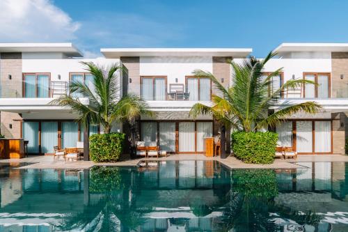 a hotel with a swimming pool in front of a building at Villas La Mar in Monterrico