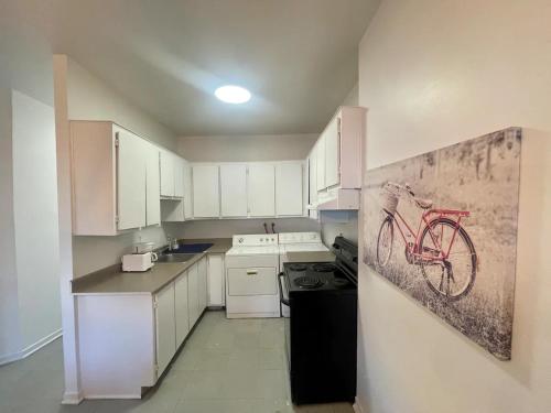 a kitchen with a red bike painting on the wall at FULL KITCHEN 12MIN from dtown Room B in Montréal