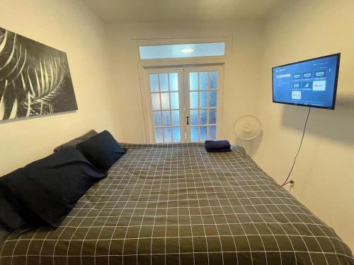 a bedroom with a bed with a tv on the wall at FULL KITCHEN 12MIN from dtown Room B in Montréal