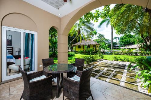 an outdoor patio with a glass table and chairs at Matapalo Diria 103 - Luxury 2BR Pool & Beachside in Tamarindo