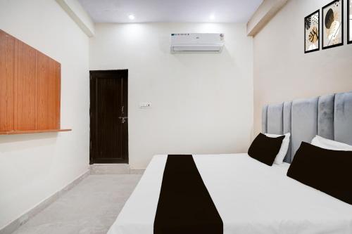 a bedroom with a bed and a black door at Hotel O Silk Inn Haveli in Jhānsi
