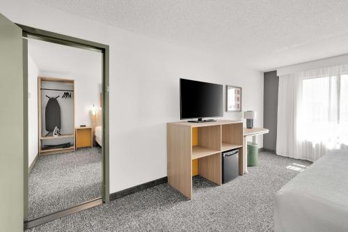a hotel room with a bed and a flat screen tv at Spark By Hilton Toronto Markham in Markham
