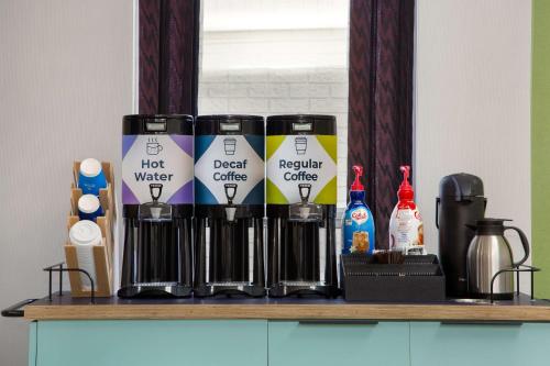 a shelf with four coffee cans on it at Spark by Hilton Brockville in Brockville