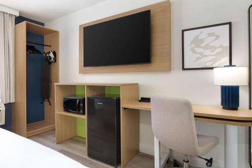 a hotel room with a desk with a tv and a chair at Spark by Hilton Brockville in Brockville