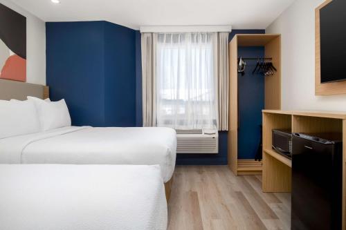 a hotel room with two beds and a window at Spark by Hilton Brockville in Brockville