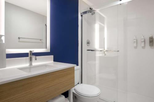 a bathroom with a toilet and a sink and a shower at Spark by Hilton Brockville in Brockville