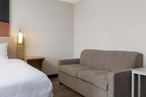 a bedroom with a bed and a chair and a bed at Spark By Hilton Woodstock in Woodstock