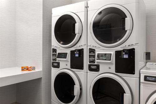 three washing machines are in a laundry room at Spark By Hilton Woodstock in Woodstock