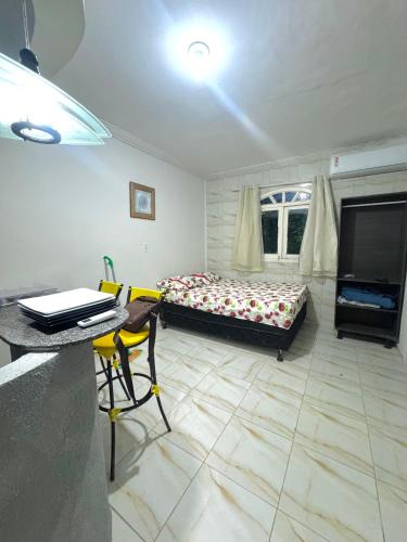 Un dormitorio con una cama, una mesa y un escritorio. en Novo hotel Maracaípe, en Porto de Galinhas