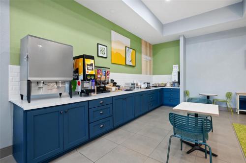 a kitchen with blue cabinets and a table and chairs at Spark by Hilton Homewood Birmingham in Birmingham