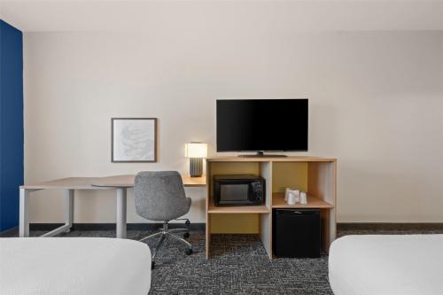 a room with a television and a desk and a chair at Spark by Hilton Homewood Birmingham in Birmingham