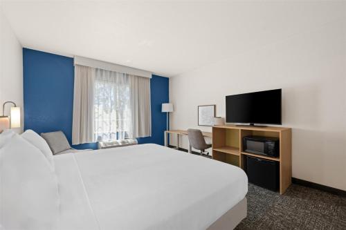 a hotel room with a large bed and a flat screen tv at Spark by Hilton Homewood Birmingham in Birmingham