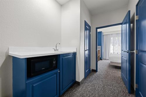 a bathroom with a sink and a blue cabinet at Spark by Hilton Homewood Birmingham in Birmingham