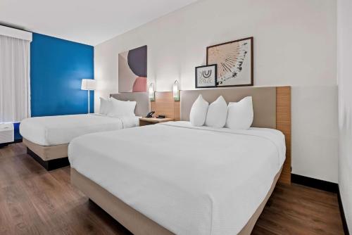 a hotel room with two beds and a large bed at Spark by Hilton Tuscaloosa University in Tuscaloosa