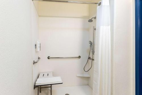 a white bathroom with a shower and a sink at Spark by Hilton Phoenix-Glendale-Peoria in Glendale