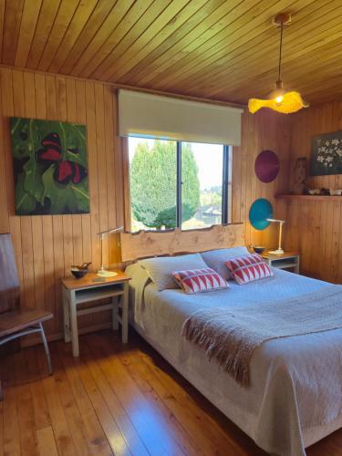 a bedroom with a bed with two pillows on it at Hostal Boutique El Vergel Azul in Castro