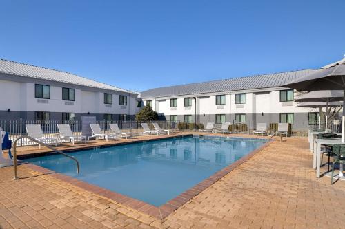 a large swimming pool with chairs and a hotel at Spark by Hilton Bentonville in Bentonville
