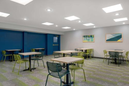 a room with tables and chairs and blue walls at Spark by Hilton Montgomery EastChase in Montgomery