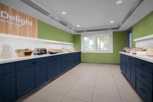a kitchen with blue cabinets and green walls at Spark by Hilton San Jose Airport in San Jose