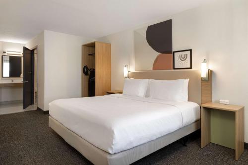 a large white bed in a hotel room at Spark By Hilton Santa Nella in Santa Nella Village