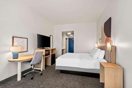 a hotel room with a bed and a desk at Spark by Hilton Phoenix East Mesa in Mesa