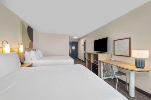 a hotel room with two beds and a desk at Spark by Hilton Bakersfield Central in Bakersfield
