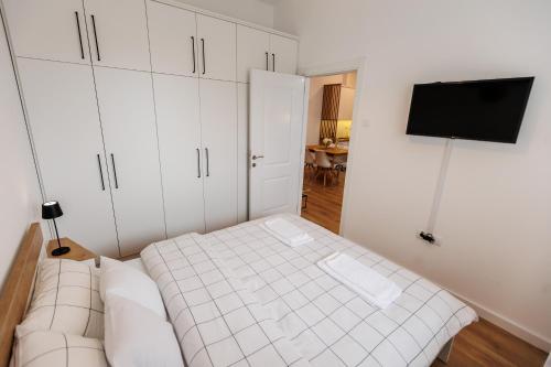 a small bedroom with a bed and a tv at Apartman Bonus in Palić